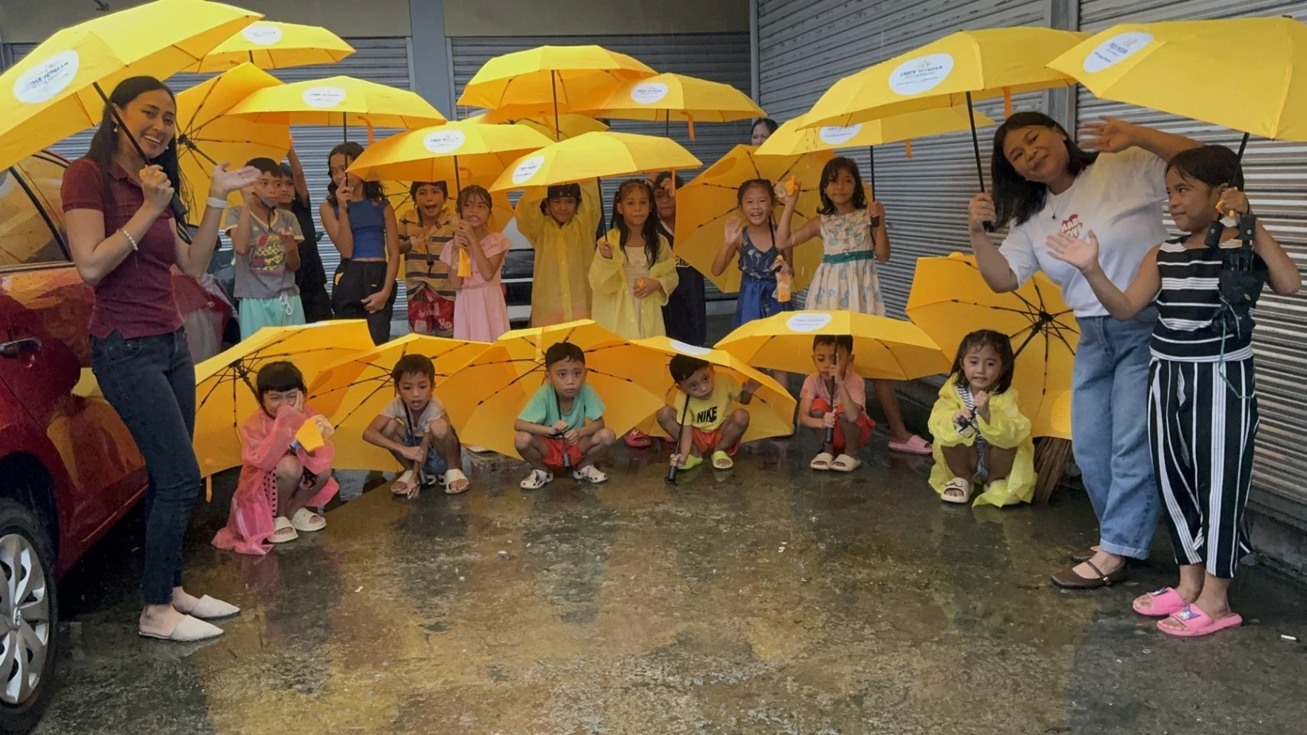 Children receiving umbrellas for the rainy season